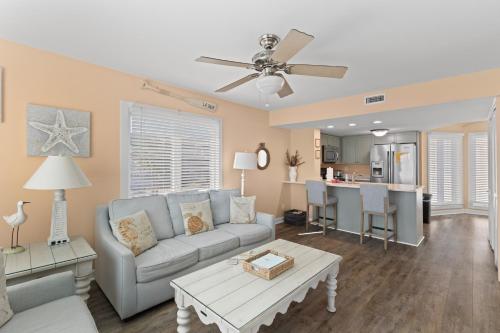a living room with a couch and a table at Port O' Call B201 - Direct Oceanfront Views in Isle of Palms