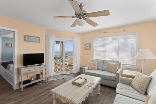 a living room with a couch and a tv at Port O' Call B201 - Direct Oceanfront Views in Isle of Palms
