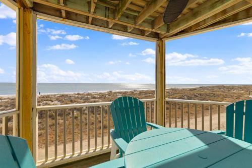 a porch with a table and chairs and a view of the beach at Port O' Call B201 - Direct Oceanfront Views in Isle of Palms