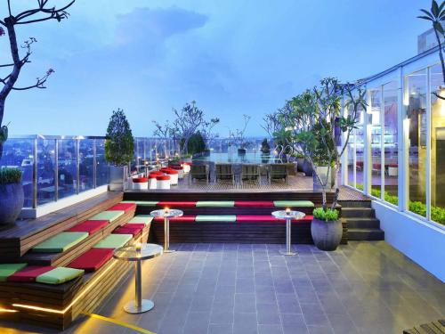 a balcony with benches and tables on a building at ibis Styles Yogyakarta in Yogyakarta