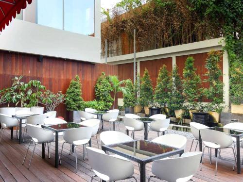 a patio with tables and chairs in a building at ibis Styles Yogyakarta in Yogyakarta