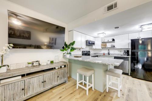 a kitchen with white cabinets and a counter with stools at Sevierville Condo with Balcony and Pool Access! in Sevierville
