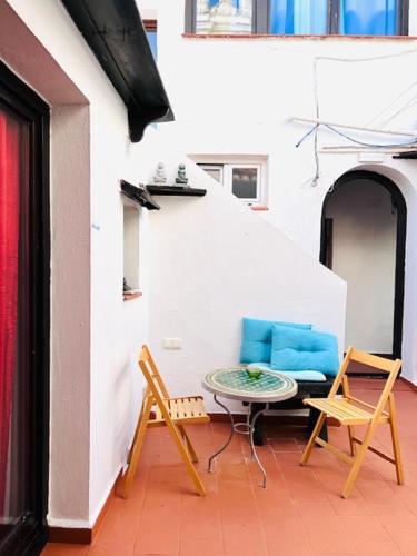 a patio with two chairs and a table in a building at El Beaterio Apartments in Tarifa