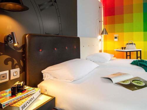 a bedroom with a white bed with a book on it at ibis Styles London Southwark - near Borough Market in London