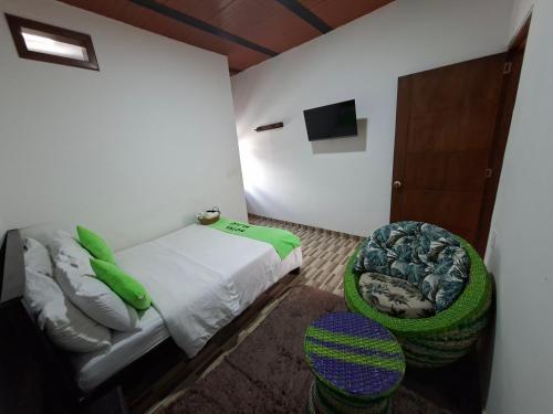 a small bedroom with a bed and a chair at Hotel Malaki in San Agustín
