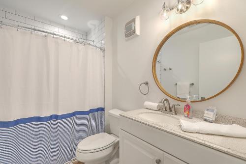 a bathroom with a sink and a toilet and a mirror at Port O' Call E302 - Top Floor Ocean View Condo! in Isle of Palms