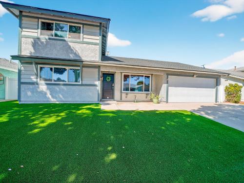 a house with a green lawn in front of it at Coastal Escape with Private Mini Golf home in Hollywood Beach