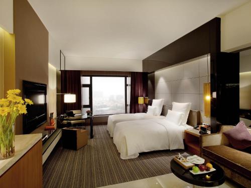 a large hotel room with a bed and a couch at Pullman Dongguan Changan in Dongguan