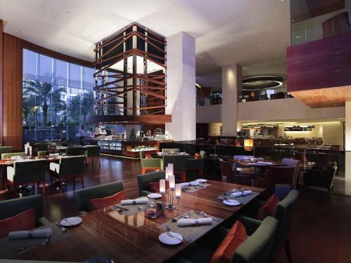 a restaurant with a large dining room with tables and chairs at Pullman Dongguan Changan in Dongguan