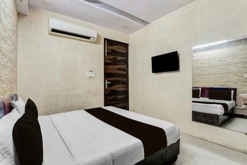 a bedroom with a bed and a tv in it at Hotel O LS BANQUET & ROOMS in New Delhi