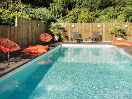 a swimming pool with chairs and a fence at ibis Styles Toulouse Cite Espace in Toulouse