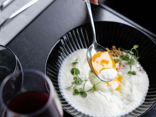 a person holding a spoon over a plate of food at ibis Styles Toulouse Cite Espace in Toulouse