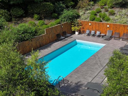 a swimming pool with chairs and a wooden fence at ibis Styles Toulouse Cite Espace in Toulouse