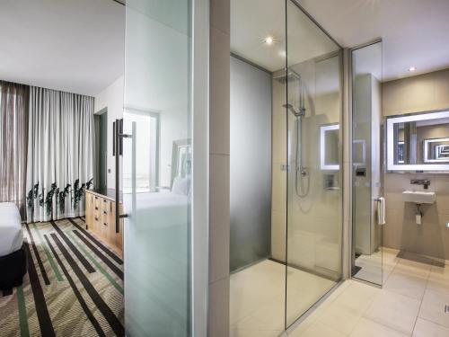 a bathroom with a glass shower and a sink at Novotel Auckland Airport in Auckland