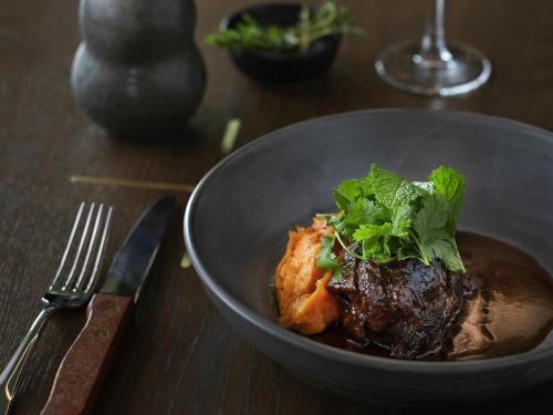 a bowl of food with meat and greens on a table at Novotel Auckland Airport in Auckland