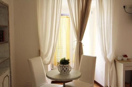 a table and chairs in a room with a window at Have A Nice Holiday - Luxury Rooms in Rome