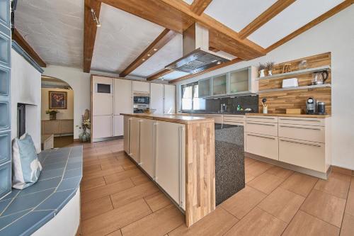 a kitchen with white cabinets and a wooden ceiling at Apartments Enzian in Rauris