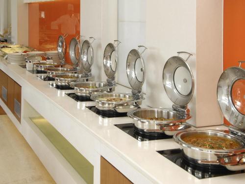 a row of bowls of food on a counter at ibis New Delhi Aerocity - An Accor Brand in New Delhi