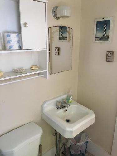 a bathroom with a sink and a toilet and a mirror at Crosswinds Motel in Old Orchard Beach