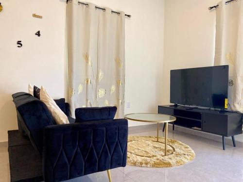 a living room with a tv and a chair and a table at Sxm Sea View Apartments in Philipsburg
