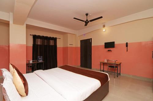 a bedroom with a bed and a flat screen tv at Hotel O Prabha Palace Lodge in Guwahati
