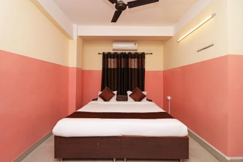 a bedroom with a bed with red and white stripes at Hotel O Prabha Palace Lodge in Guwahati