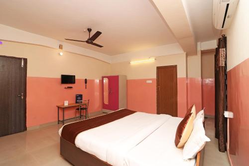 a bedroom with a bed and a ceiling fan at Hotel O Prabha Palace Lodge in Guwahati