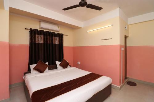 a bedroom with a bed with a ceiling fan at Hotel O Prabha Palace Lodge in Guwahati