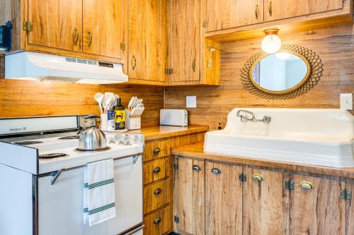 cocina con armarios de madera y fregadero blanco en Historic Retreat with Mtn Views in Pioche!, en Pioche