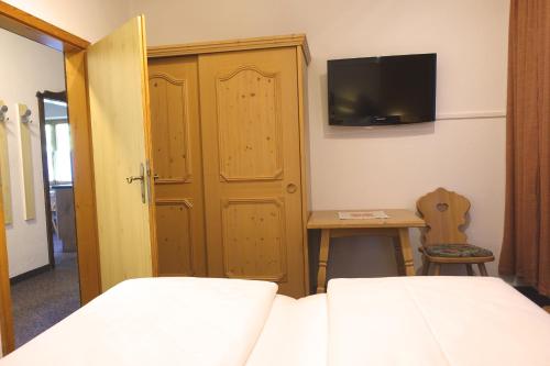 a bedroom with two beds and a tv on the wall at Haus Martina in Hochfügen - ohne Verpflegung in Hochfugen