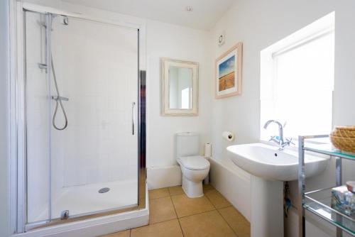 Un baño con ducha, inodoro y lavabo. en South Lodge West, en Holkham