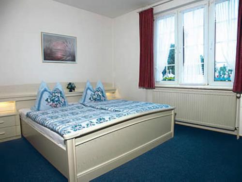 a bedroom with a bed with blue sheets and a window at Haus Nordseegruß 2 in Cuxhaven
