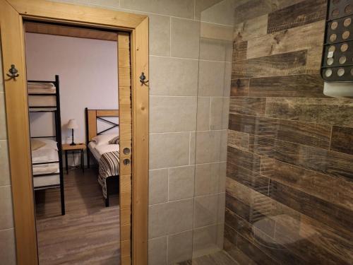 a bathroom with a walk in shower next to a bedroom at CHALET ASKALA JASNÁ in Demanovska Dolina