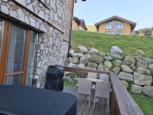 a deck with two chairs and a trash can at CHALET ASKALA JASNÁ in Demanovska Dolina