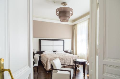 a bedroom with a bed and a table and chairs at Hotel Spiess & Spiess in Vienna