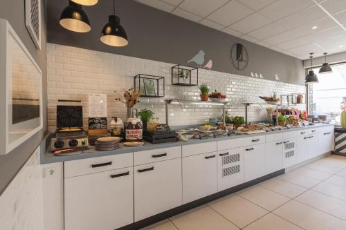 a kitchen with white cabinets and a counter top at Garner Hotel Berlin - Wilmersdorf by IHG in Berlin