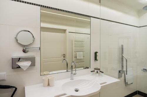 a white bathroom with a sink and a mirror at Hotel Spiess & Spiess in Vienna