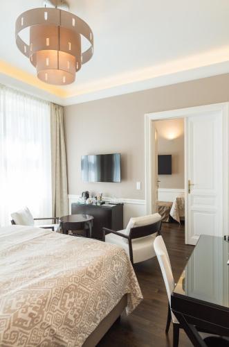 a bedroom with a bed and a table and chairs at Hotel Spiess & Spiess in Vienna