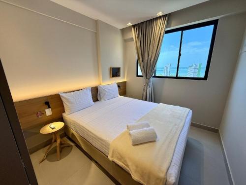 a bedroom with a large bed with a window at Studio Design 3 Apt 801 -Mandi Hospitalidade in Maceió