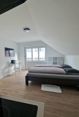 a bedroom with a large bed and a table at Casa Maria Bern in Bern