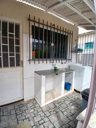 a kitchen with a sink in a room with a door at Casa aconchegante à 800 m da praia in Marataizes