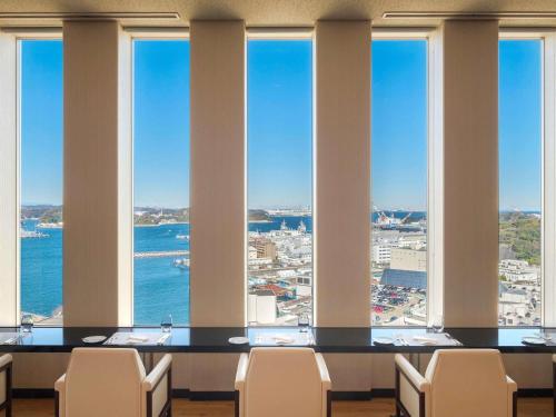 a table in a room with a view of the ocean at Mercure Yokosuka in Yokosuka