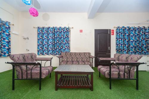 Zimmer mit 3 Stühlen, einem Tisch und einem Sofa in der Unterkunft Hotel O B Square Homes in Singānallūr