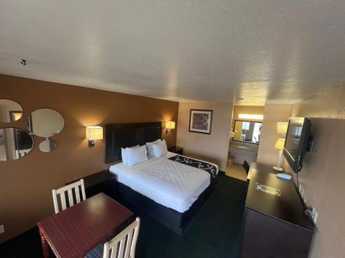 a hotel room with a bed and a table at Antlers Inn in Falfurrias