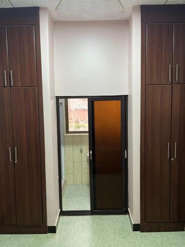 a room with wooden cabinets and a glass door at Paradise in najjera in Kampala