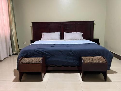 a bedroom with a large bed with a wooden headboard at Paradise in najjera in Kampala