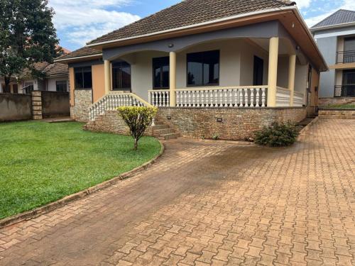 a house with a brick driveway in front of it at Paradise in najjera in Kampala