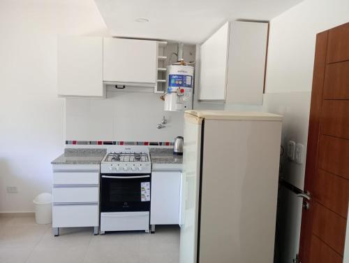 a kitchen with white cabinets and a refrigerator at Colon Sun in Colón
