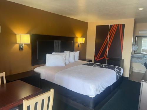 a hotel room with a large bed and a table at Antlers Inn in Falfurrias