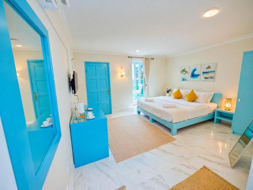 a bedroom with a bed in a room with blue doors at SunSeaSurf Maldives in Thulusdhoo